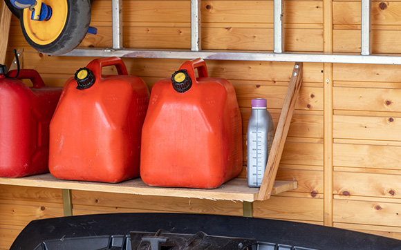 Gas cans on a shelf inside a shed