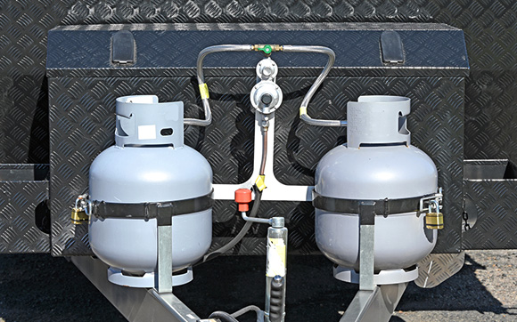 Truck trailer with two propane tanks secured to a rack